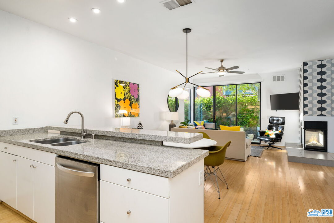 665 East Arenas Road Palm Springs, CA 92262 - Photo 15 of 40 a kitchen with stainless steel appliances granite countertop a sink and a wooden floor