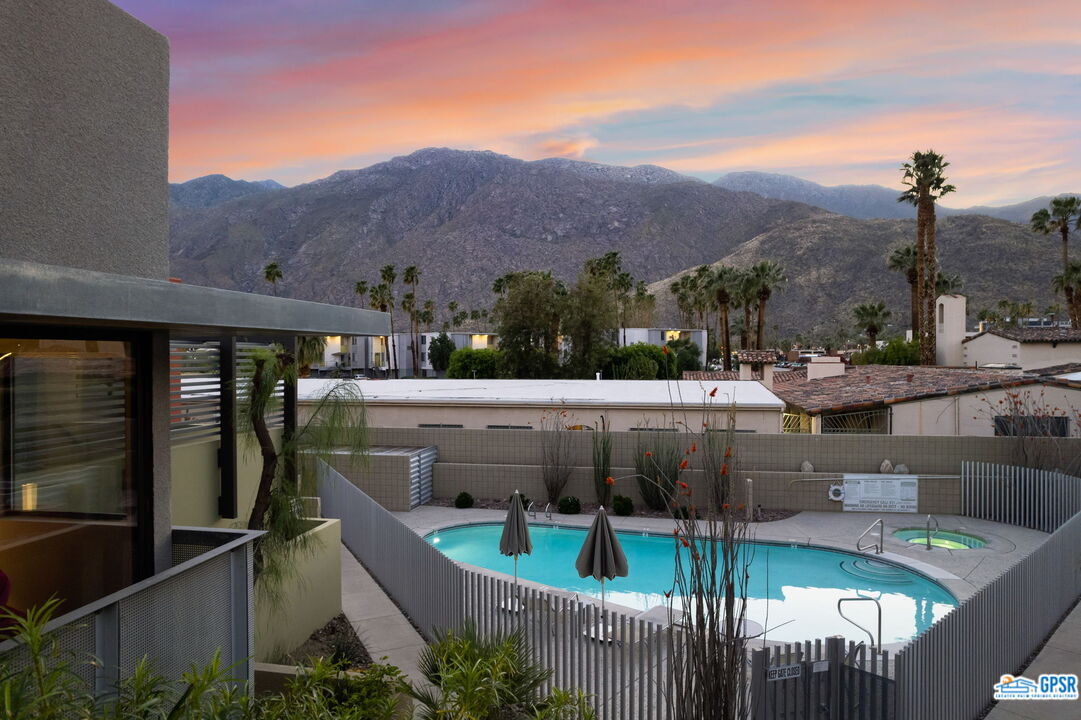 665 East Arenas Road Palm Springs, CA 92262 - Photo 29 of 40 a view of houses with a swimming pool and a yard