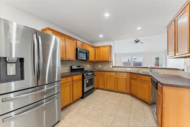 a kitchen with stainless steel appliances granite countertop a refrigerator sink and stove