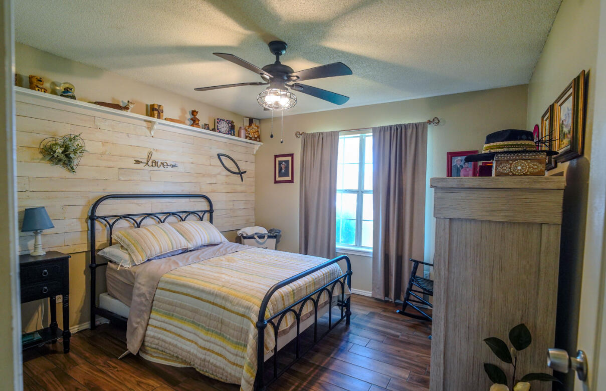 603 15th Street Shallowater, TX 79363 - Photo 12 of 18 a bedroom with a bed and a chandelier