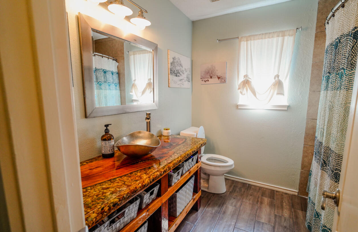 603 15th Street Shallowater, TX 79363 - Photo 13 of 18 a bathroom with a toilet sink and mirror