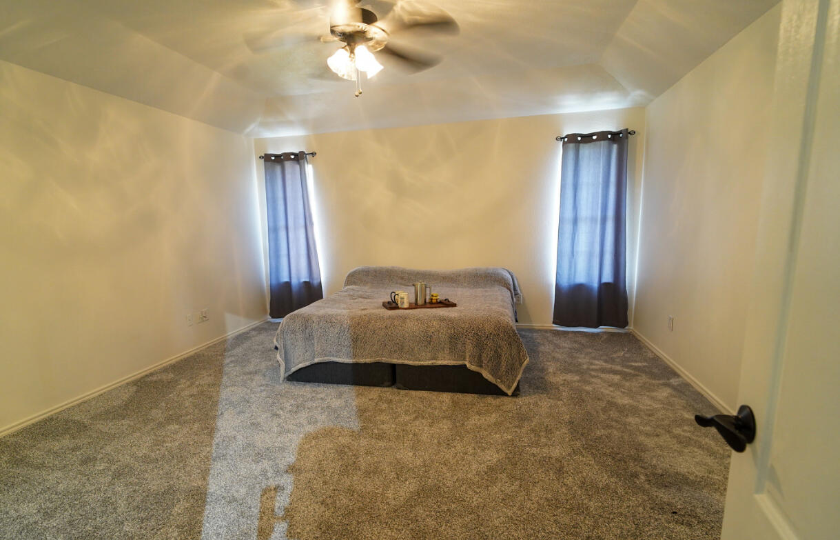 603 15th Street Shallowater, TX 79363 - Photo 6 of 18 a bedroom with a bed and a chandelier