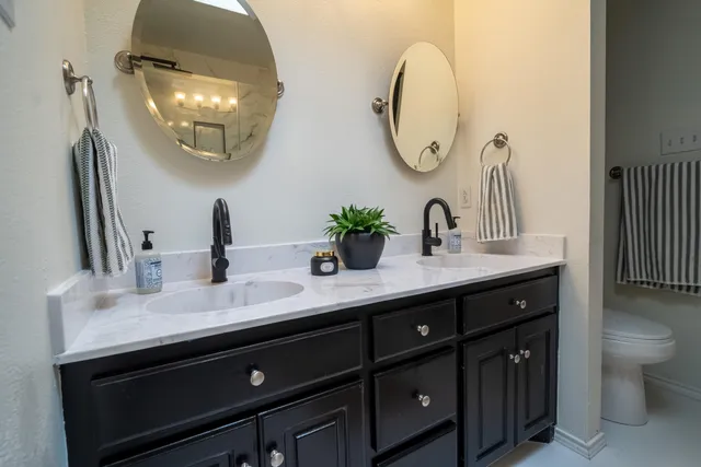 a bathroom with a double vanity sink and a mirror