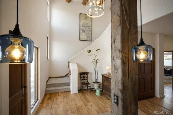 a view of a livingroom with wooden floor and staircase