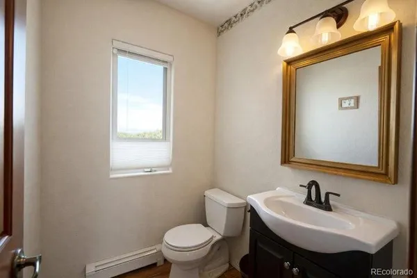 a bathroom with a toilet sink and mirror