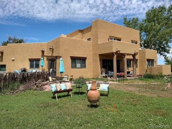 a view of a house with backyard sitting area and garden