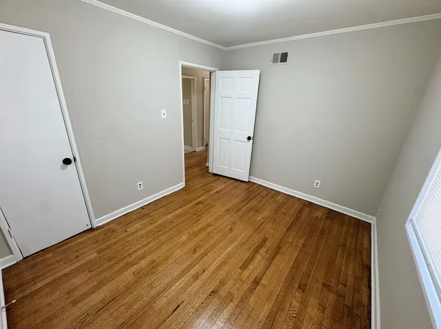 a view of an empty room with wooden floor