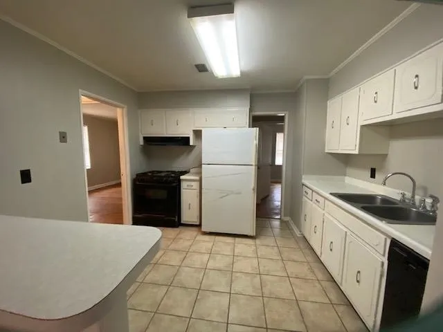 a kitchen with a sink a refrigerator and cabinets