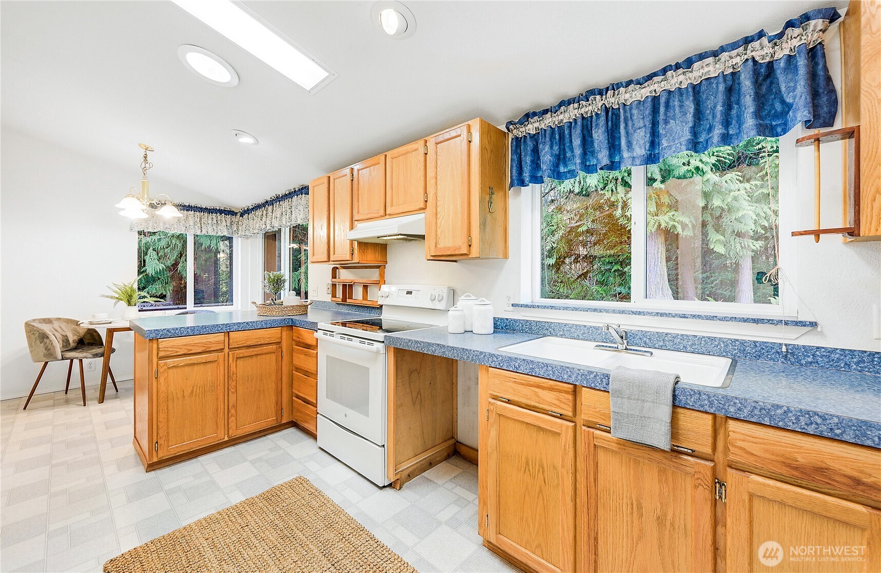 2399 Highland Loop Port Townsend, WA 98368 - Photo 7 of 31 a kitchen with wooden cabinets a sink a stove a window and appliances