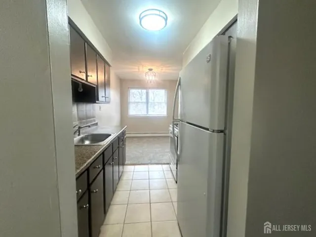 a kitchen with granite countertop a refrigerator and a sink