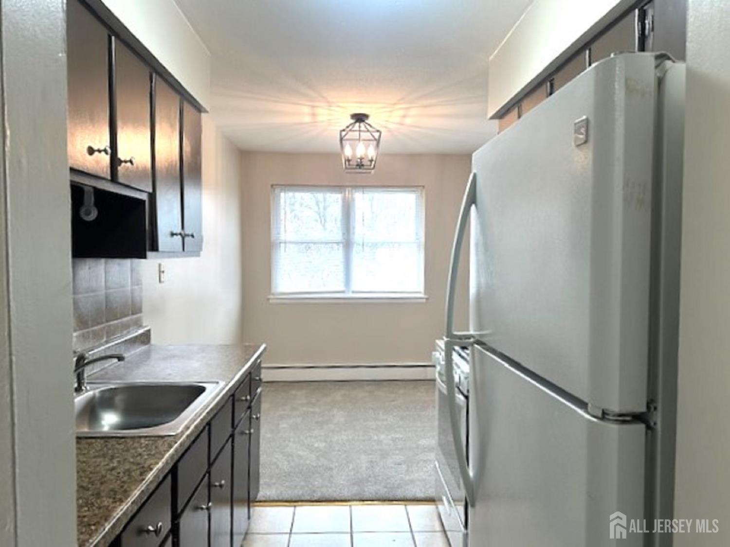 8 Manchester Court, Unit F Freehold, NJ 07728 - Photo 8 of 13 a kitchen with stainless steel appliances granite countertop a sink stove and refrigerator