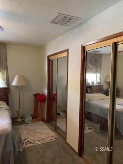 300 South Locust Street Ridgecrest, CA 93555 - Photo 12 of 23 a bedroom with a bed and a mirror