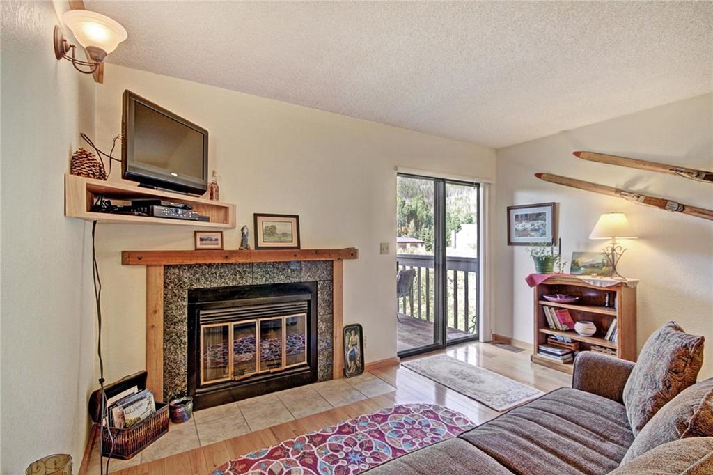 570 Bills Ranch Road, Unit 235 Frisco, CO 80443 - Photo 2 of 25 a living room with furniture a flat screen tv and a fireplace