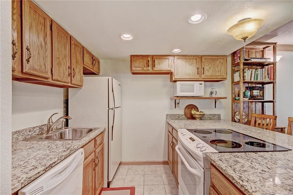 570 Bills Ranch Road, Unit 235 Frisco, CO 80443 - Photo 13 of 25 a kitchen that has a sink wooden cabinets and stainless steel appliances