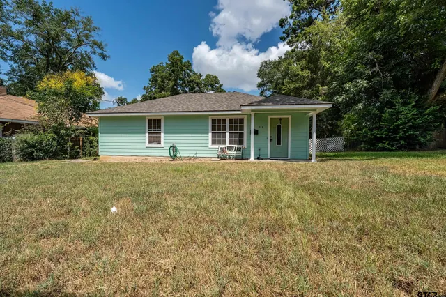 a view of house with outdoor space and garden