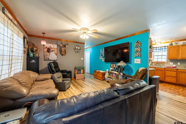 a living room with furniture a flat screen tv and kitchen view