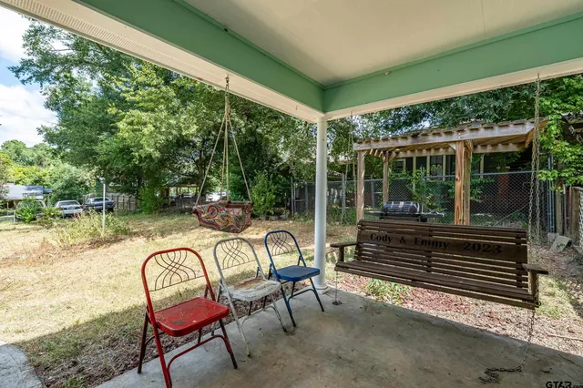 a outdoor view with a sitting space and large trees