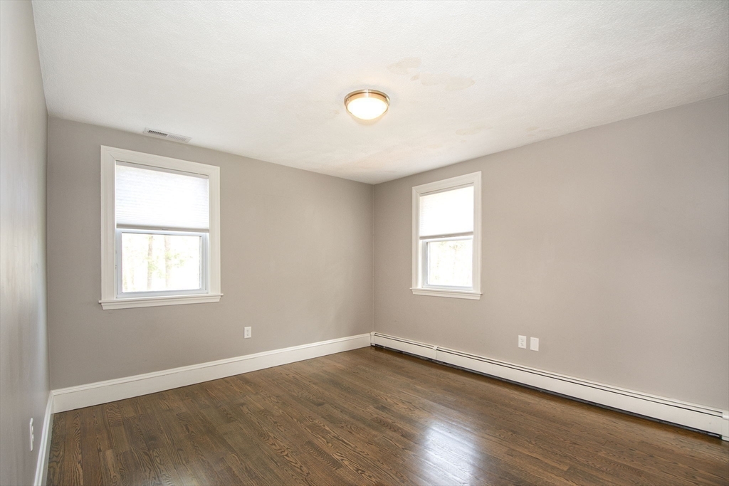 474 King Street, Unit 474 Cohasset, MA 02025 - Photo 11 of 18 an empty room with wooden floor and windows