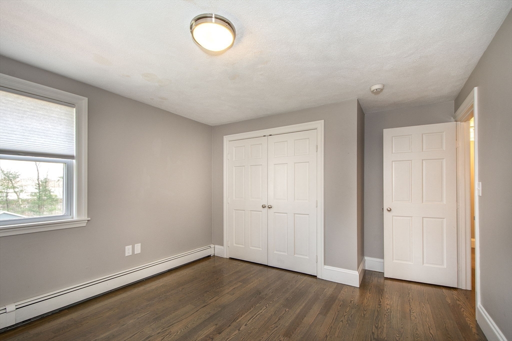 474 King Street, Unit 474 Cohasset, MA 02025 - Photo 12 of 18 an empty room with wooden floor and windows