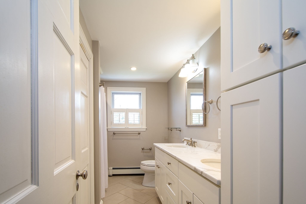 474 King Street, Unit 474 Cohasset, MA 02025 - Photo 9 of 18 a bathroom with a sink a toilet and a mirror