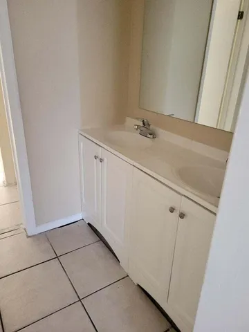 a view of a closet with white cabinets
