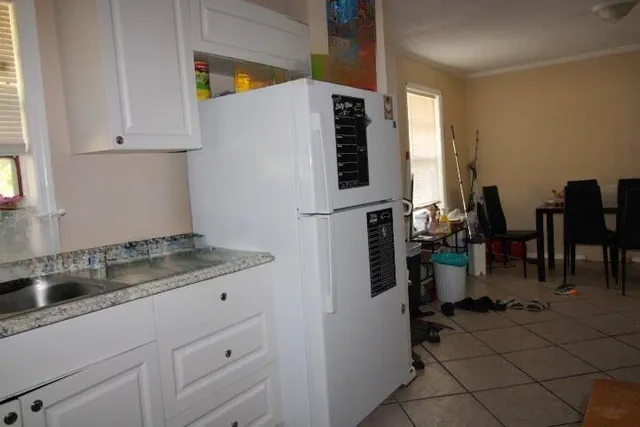 a kitchen with stainless steel appliances a sink a stove and white cabinets