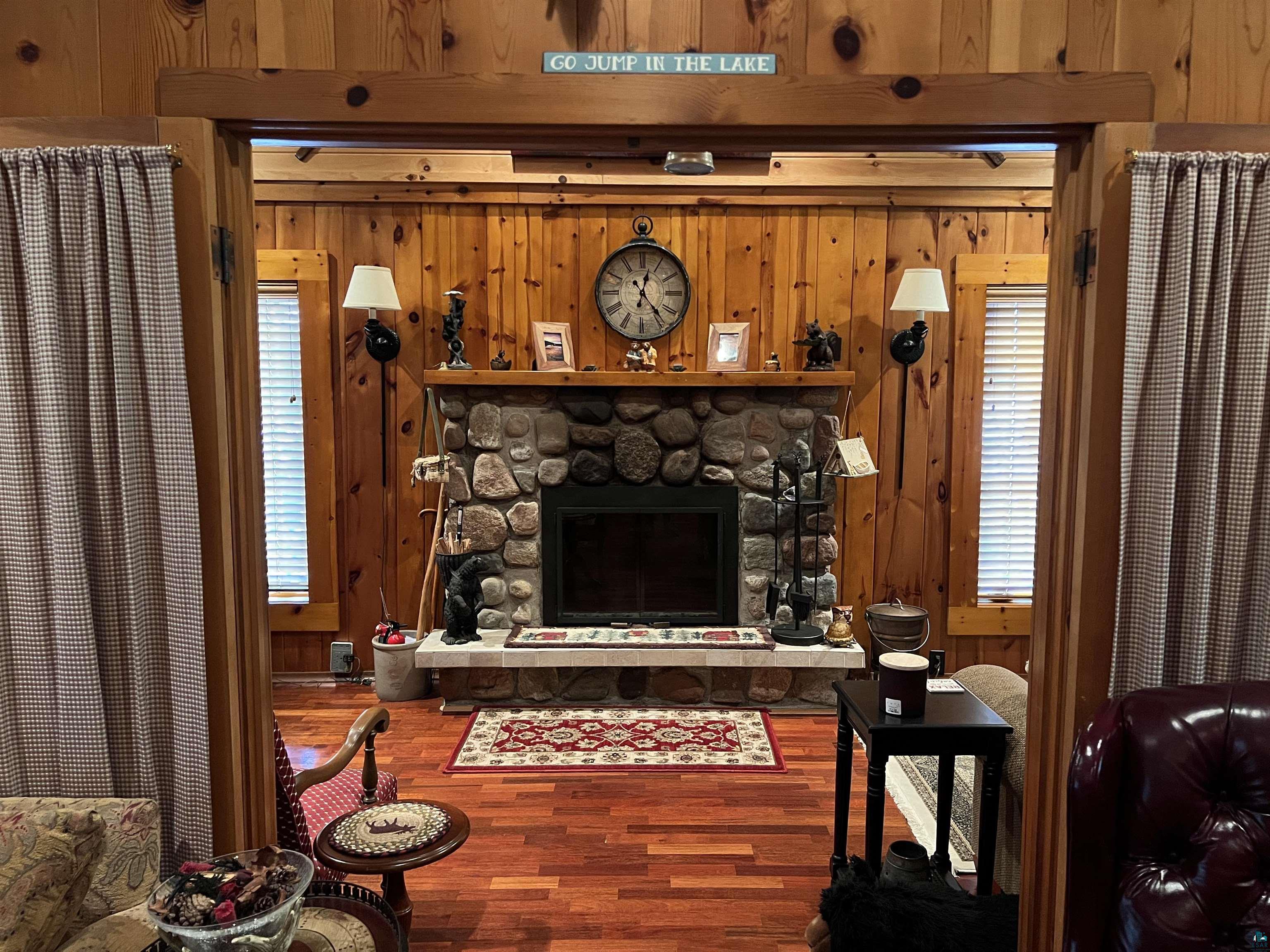 46835 Behan Drive Cable, WI 54821 - Photo 21 of 42 Living room featuring wood walls, a fireplace, and a wealth of natural light