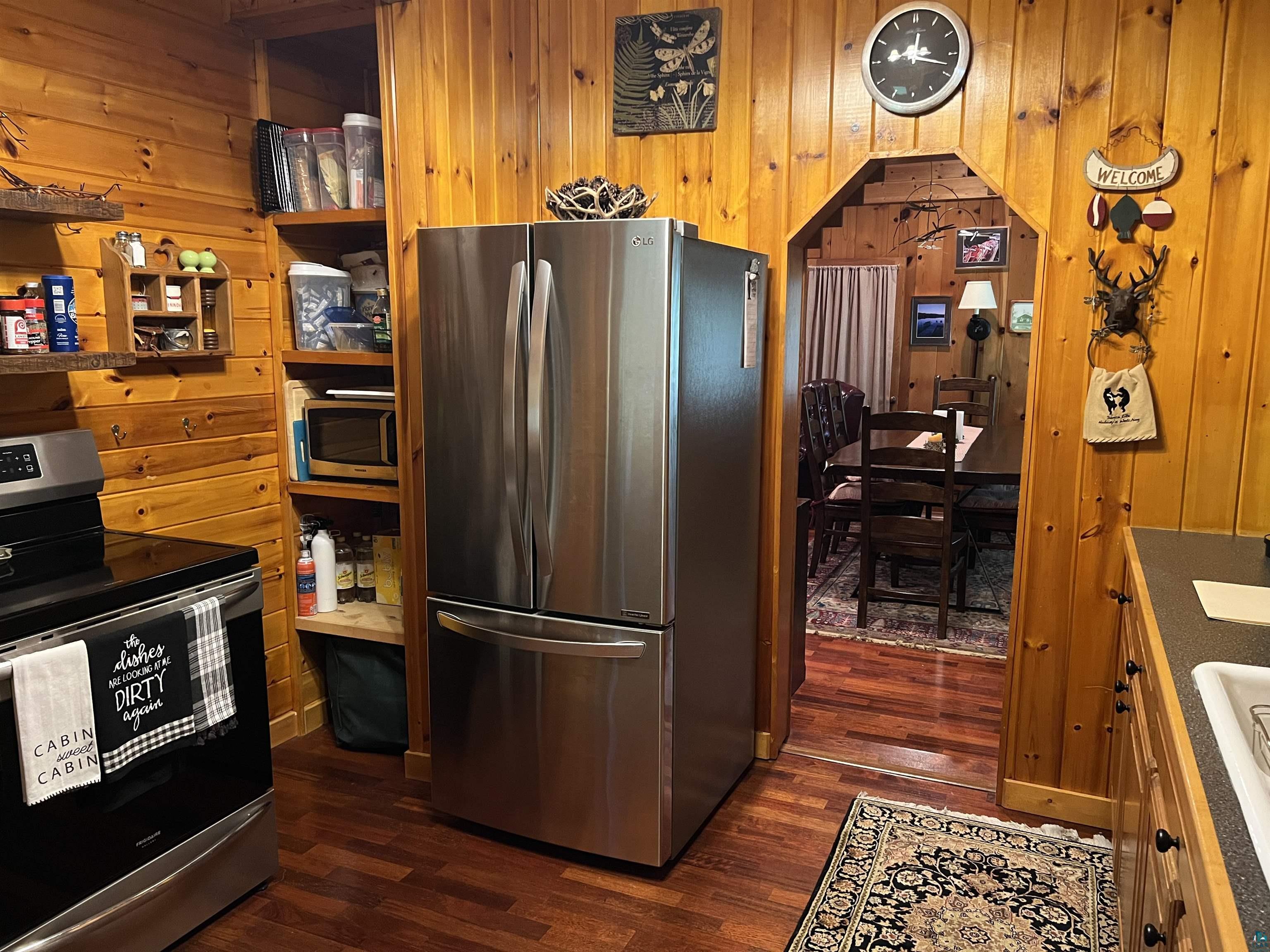 46835 Behan Drive Cable, WI 54821 - Photo 7 of 42 Kitchen with wood walls, stainless steel appliances, and dark hardwood / wood-style floors