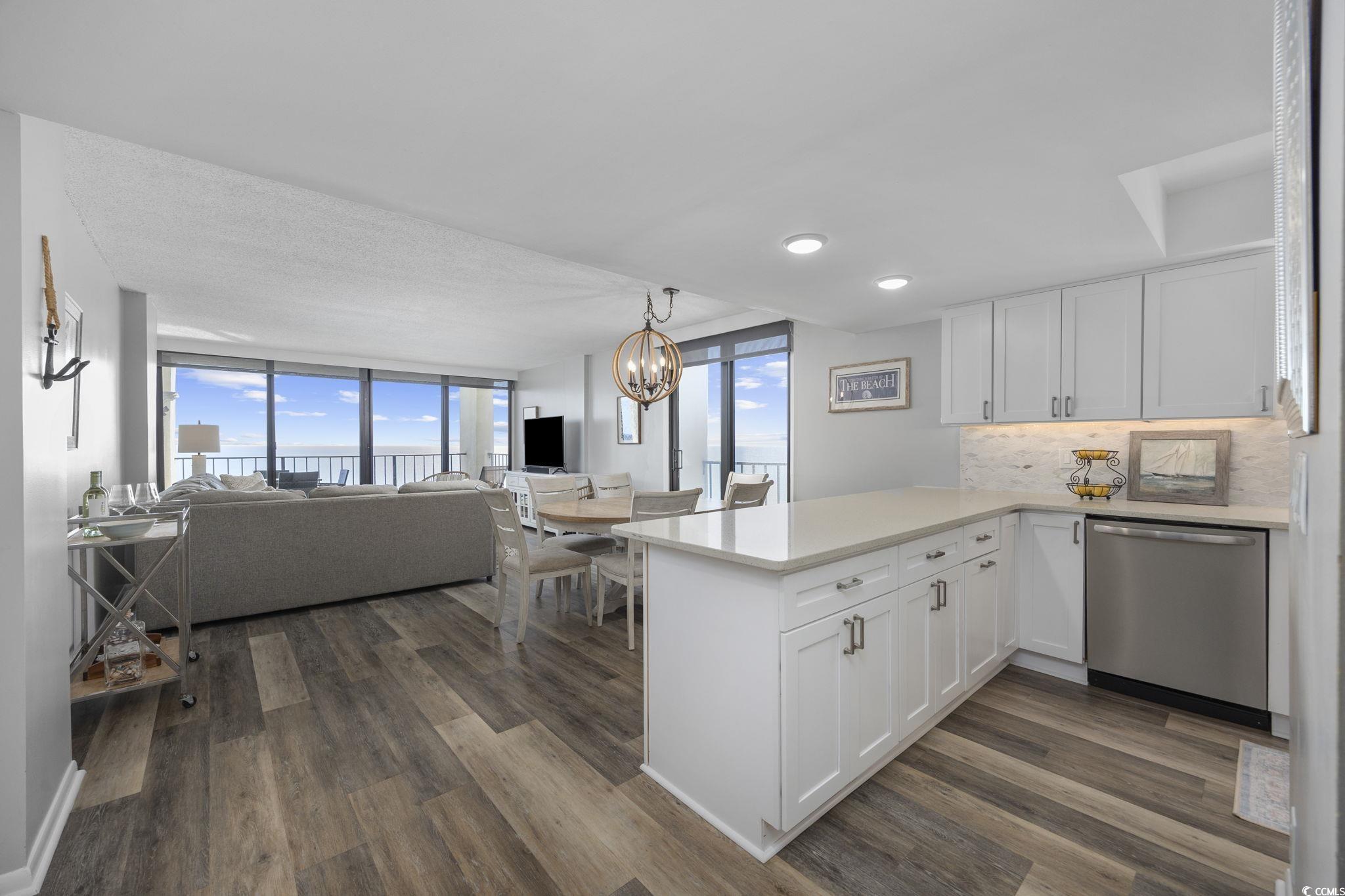 10100 Beach Club Drive, Unit 14F Myrtle Beach, SC 29572 - Photo 38 of 40 Kitchen featuring white cabinetry, decorative backsplash, stainless steel dishwasher, open floor plan, and a wall of windows