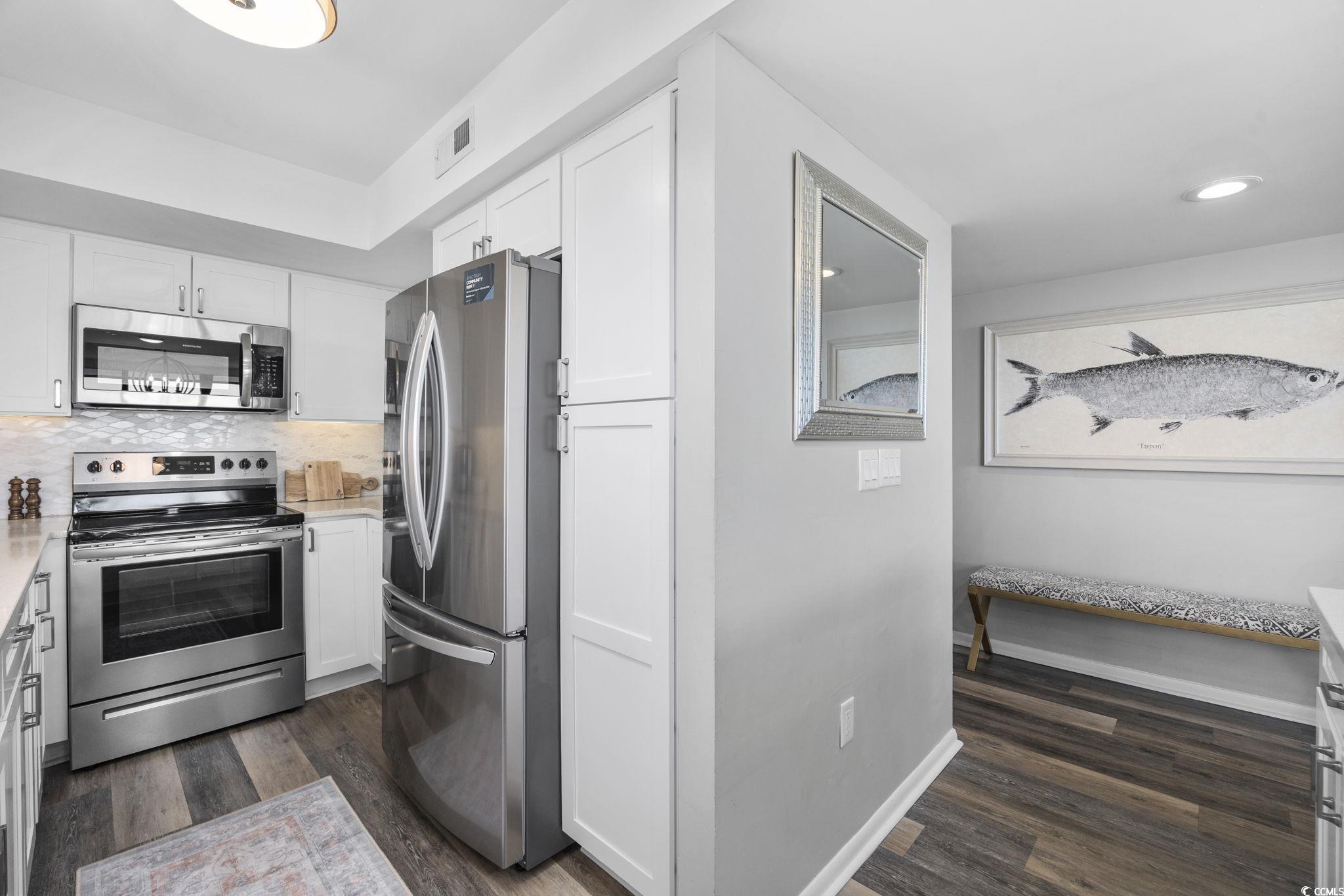 10100 Beach Club Drive, Unit 14F Myrtle Beach, SC 29572 - Photo 15 of 40 Kitchen featuring stainless steel appliances, white cabinets, backsplash, and dark wood-style flooring