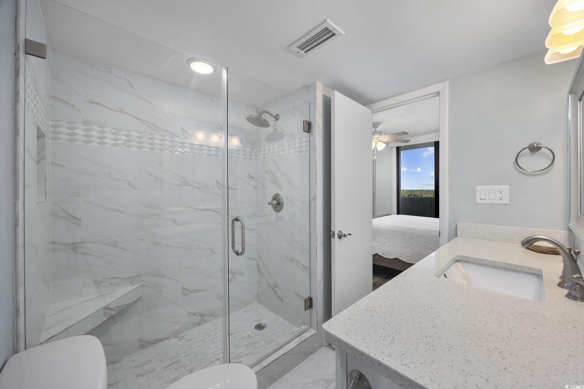 10100 Beach Club Drive, Unit 14F Myrtle Beach, SC 29572 - Photo 23 of 40 Bathroom with connected bathroom, vanity, a marble finish shower, recessed lighting, and ceiling fan