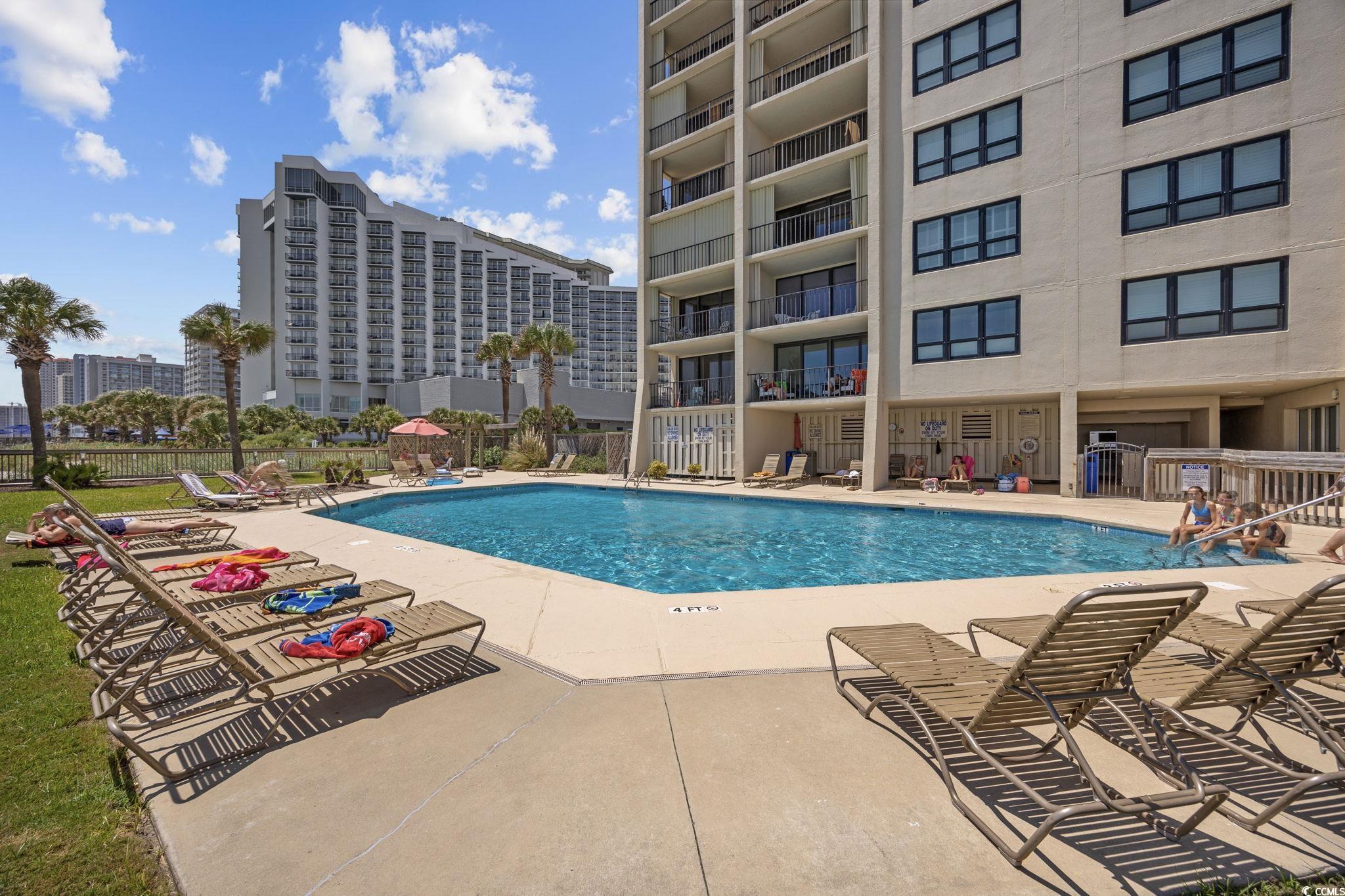 10100 Beach Club Drive, Unit 14F Myrtle Beach, SC 29572 - Photo 32 of 40 Community pool featuring a patio
