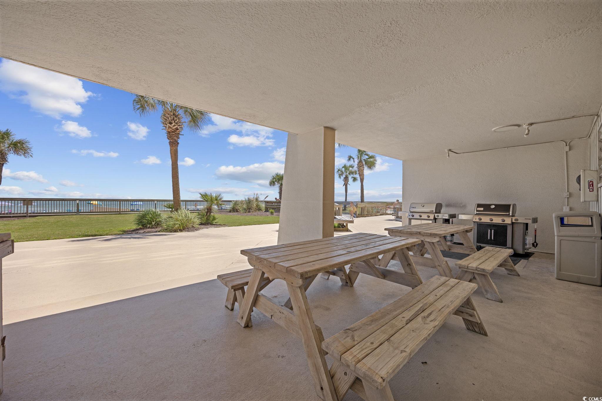 10100 Beach Club Drive, Unit 14F Myrtle Beach, SC 29572 - Photo 36 of 40 View of patio featuring outdoor dining space, area for grilling, and a water view