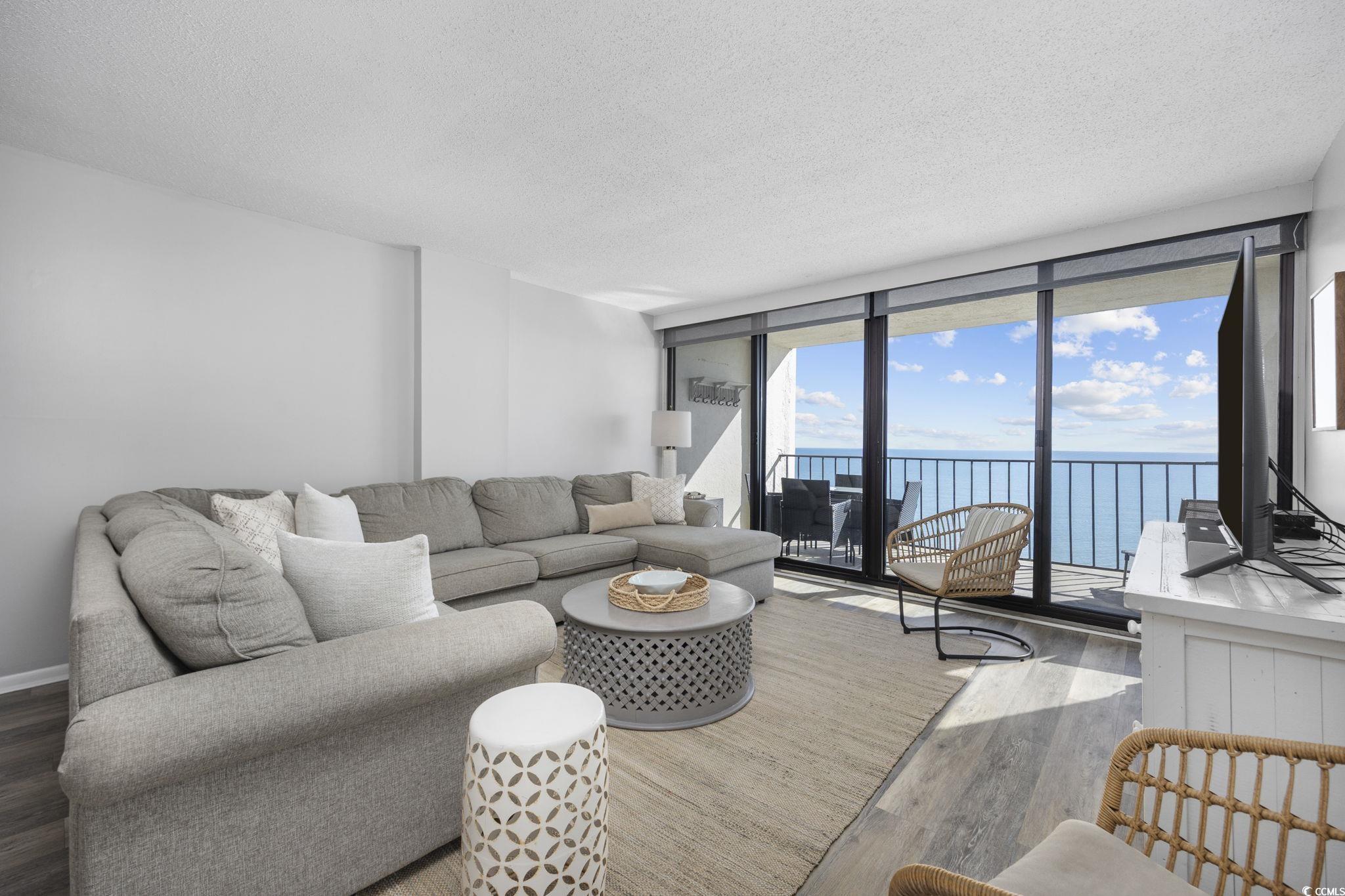 10100 Beach Club Drive, Unit 14F Myrtle Beach, SC 29572 - Photo 6 of 40 Living room with expansive windows, a textured ceiling, and wood finished floors
