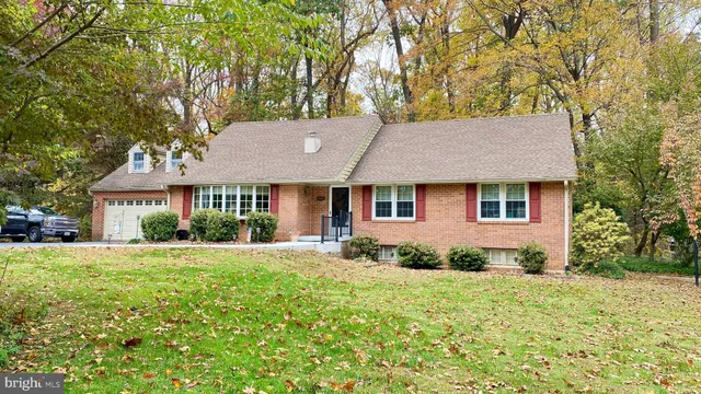 a front view of a house with a yard and trees