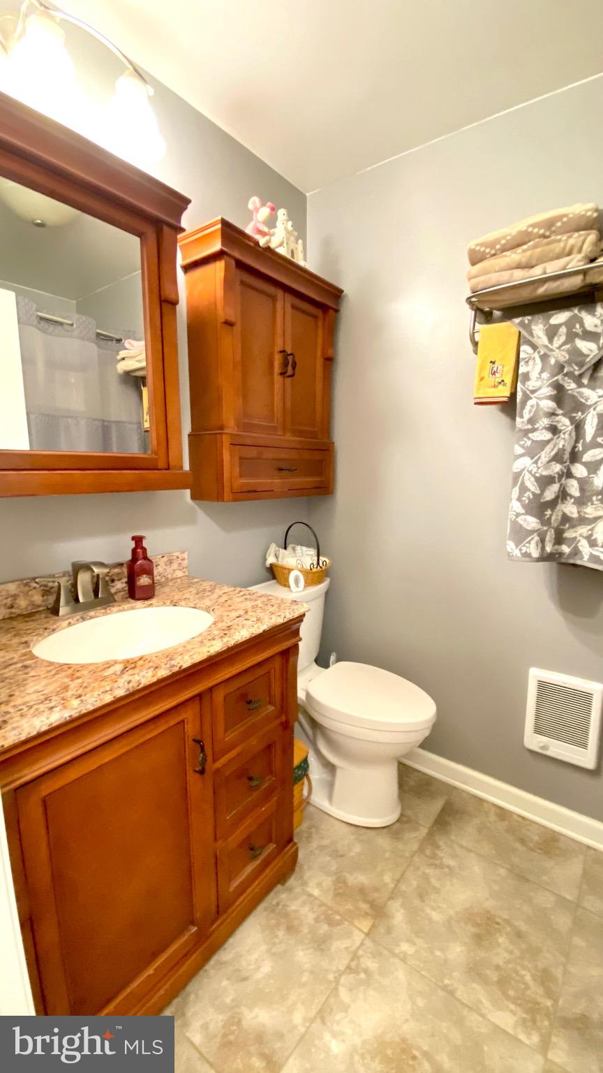 13904 Blenheim Road North Phoenix, MD 21131 - Photo 21 of 37 a bathroom with a granite countertop toilet sink and mirror