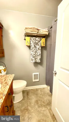 a bathroom with a granite countertop toilet and a sink