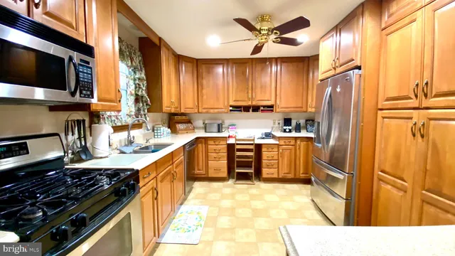 a kitchen with a refrigerator a sink and wooden cabinets