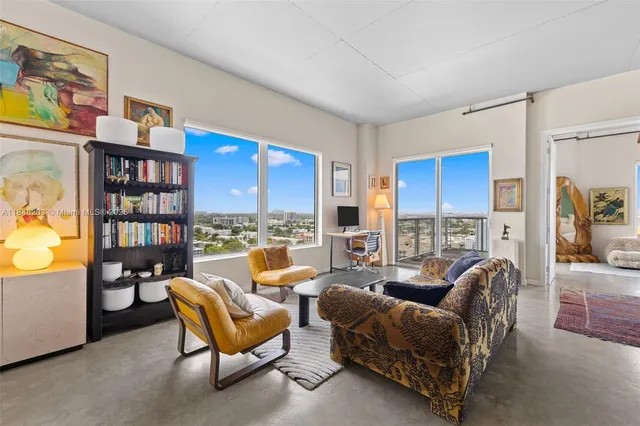 a living room with furniture a rug and a book shelf