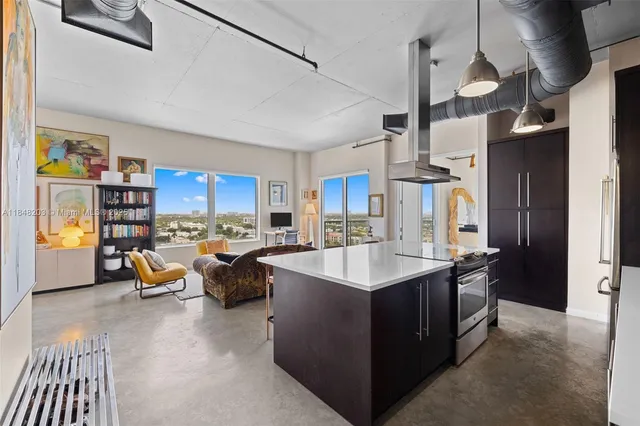 a kitchen with counter top space and living room view