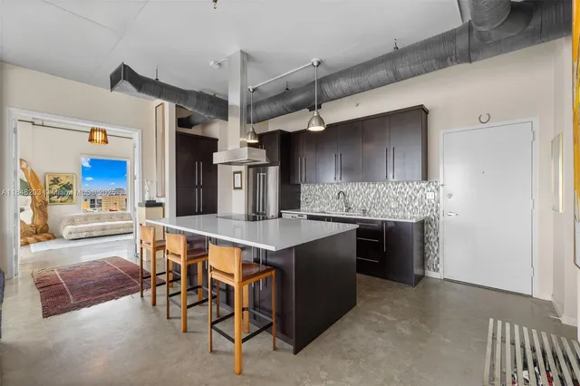 a kitchen with stainless steel appliances kitchen island a table and chairs in it