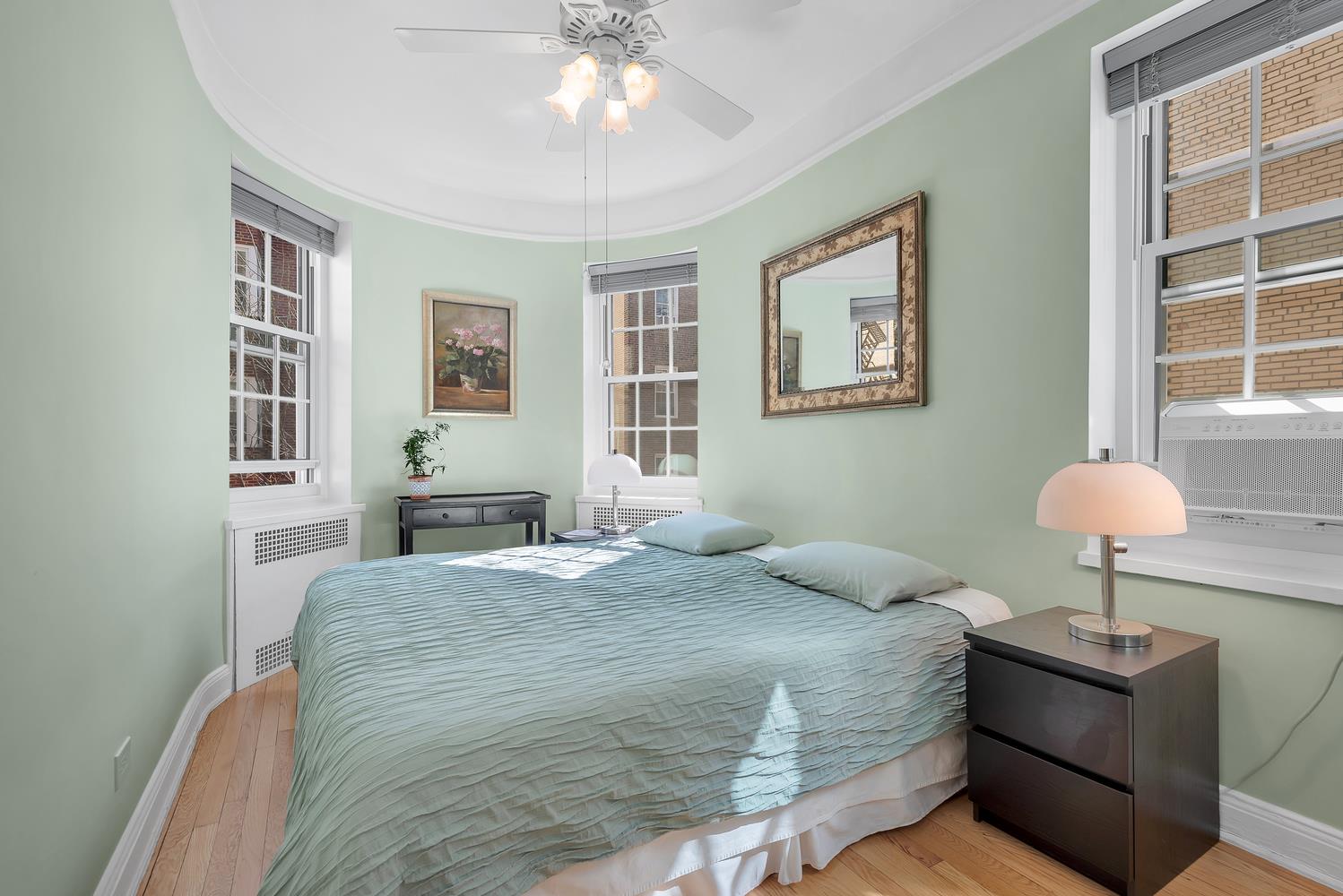 35-25 77th Street, Unit B44 Queens, NY 11372 - Photo 5 of 7 a bedroom with a bed and a chandelier