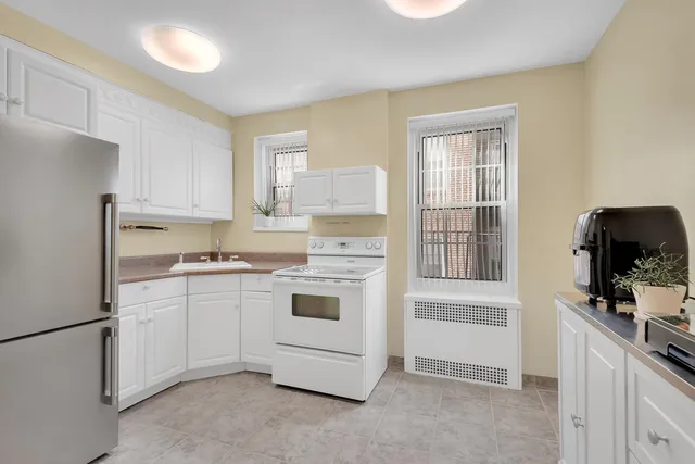 a kitchen with white cabinets and white appliances