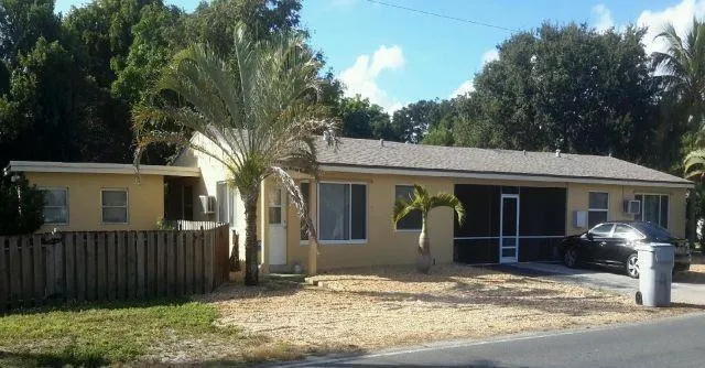 a view of a house with a yard and large tree