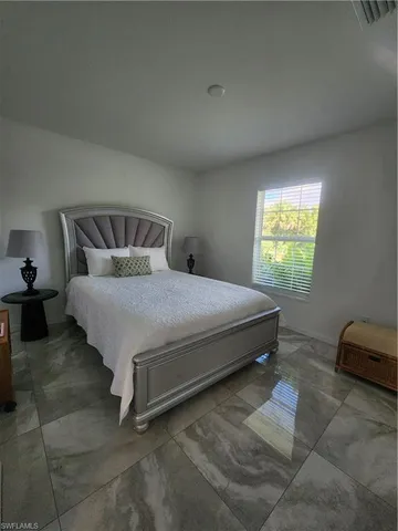 a large bed sitting in a bedroom next to a window