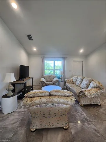a living room with couches and a flat screen tv