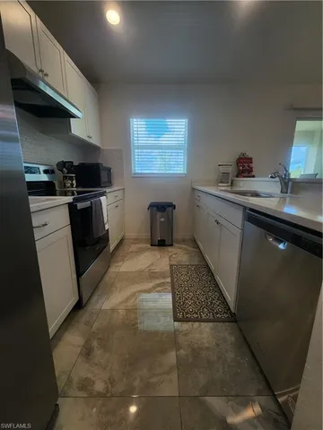 a kitchen with a sink cabinets and window