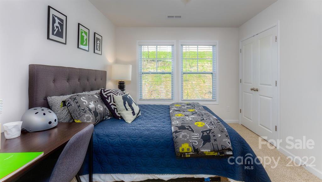 131 Creekview Road Hendersonville, NC 28792 - Photo 21 of 30 a bedroom with furniture and a wooden floor
