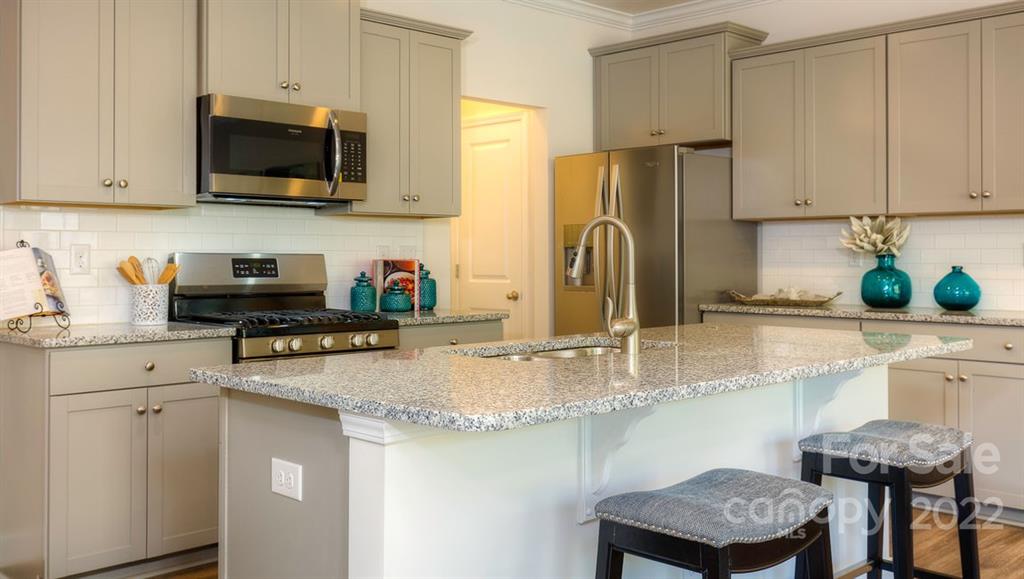 131 Creekview Road Hendersonville, NC 28792 - Photo 6 of 30 a kitchen with stainless steel appliances granite countertop a sink a stove a microwave a refrigerator and cabinets