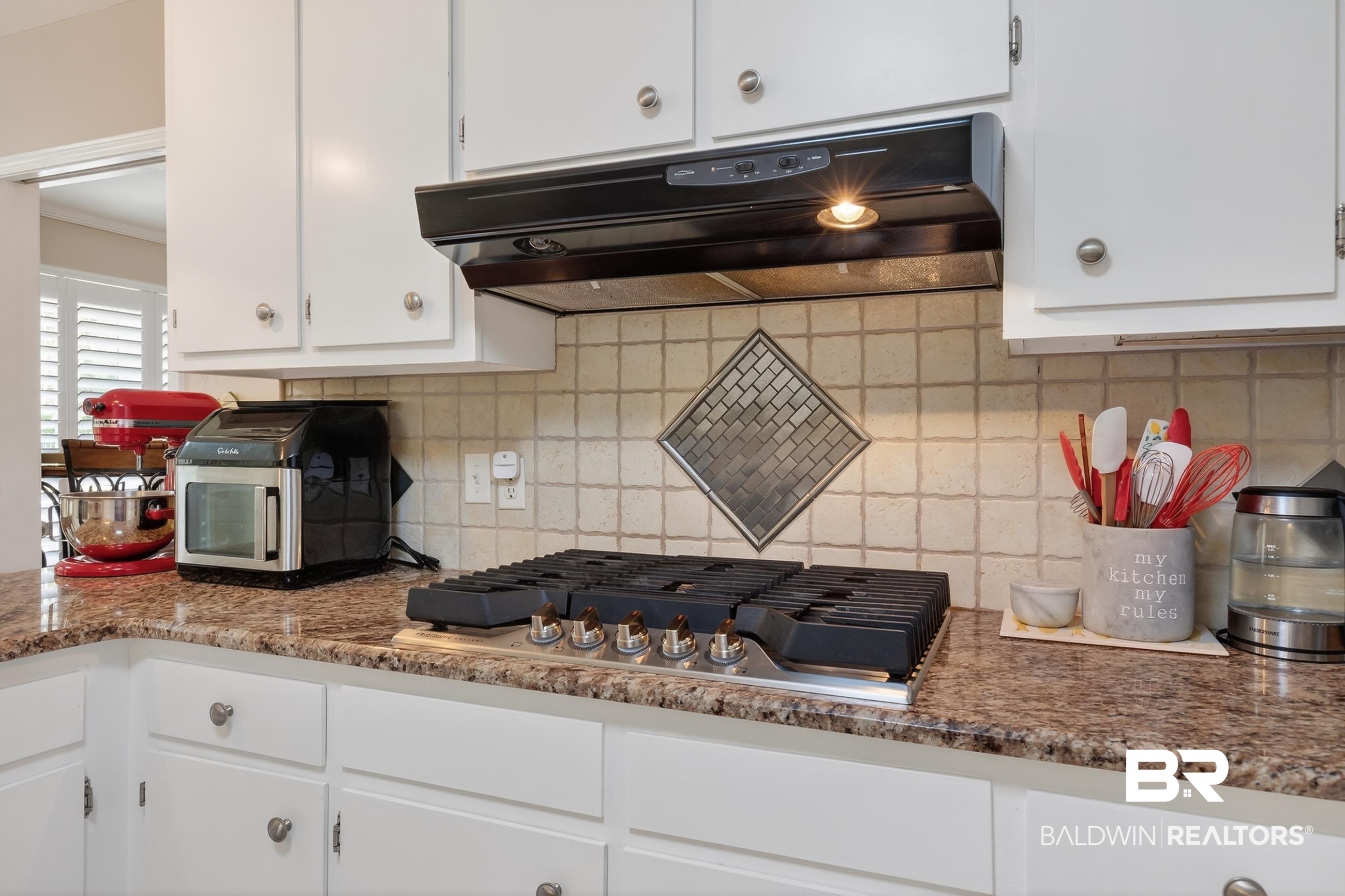 1271 Spring Valley Drive South Mobile, AL 36693 - Photo 15 of 56 Kitchen with white cabinetry, range hood, backsplash, stainless steel gas cooktop, and light stone counters